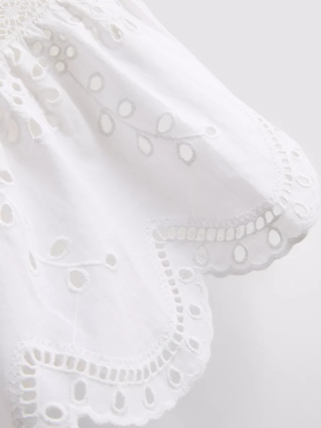 Blusa con broderie de algodón y lazo en el frente