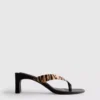 Mules con zapatos de tacón y tiras entre los dedos con estampado animal