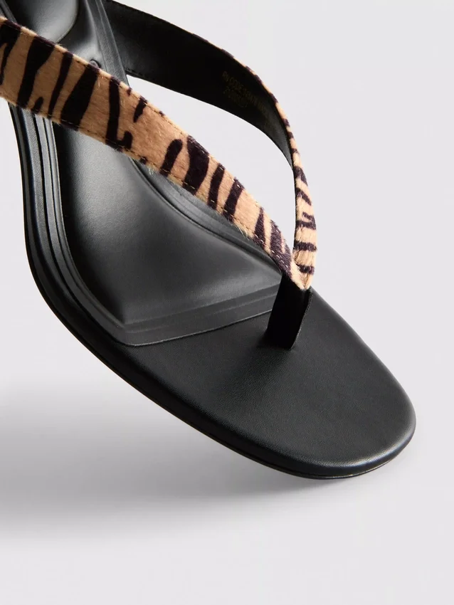 Mules con zapatos de tacón y tiras entre los dedos con estampado animal