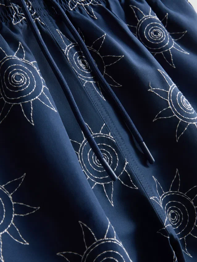 Pantalones cortos con sol bordado