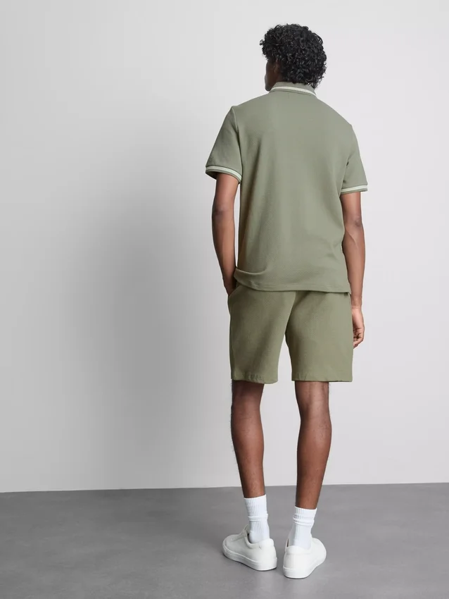 Polo con cuello con cremallera y textura