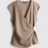 Top ajustado con cuello en V y detalles metálicos