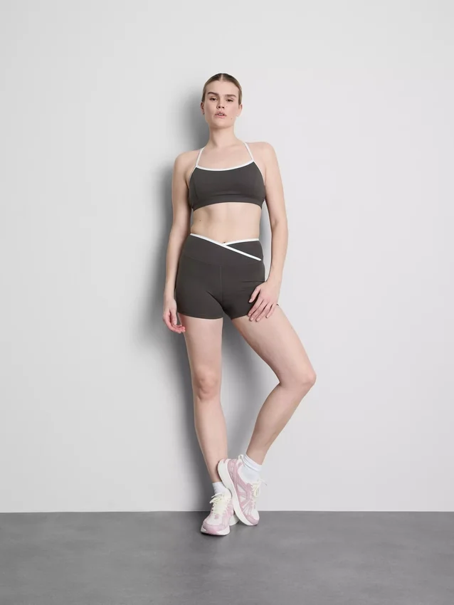 Top corto deportivo con espalda cruzada y ribetes en contraste