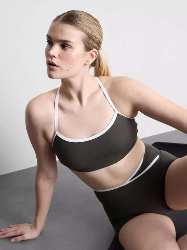 Top corto deportivo con espalda cruzada y ribetes en contraste