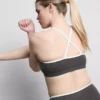 Top corto deportivo con espalda cruzada y ribetes en contraste
