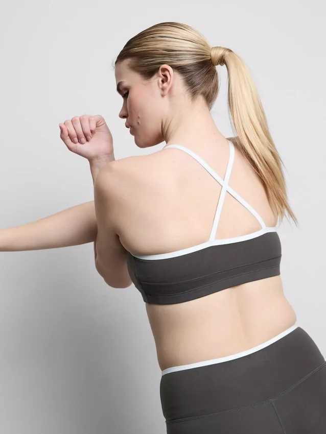 Top corto deportivo con espalda cruzada y ribetes en contraste