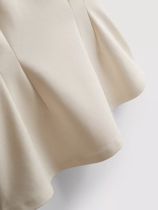 Top sin mangas con peplum y cuello en V