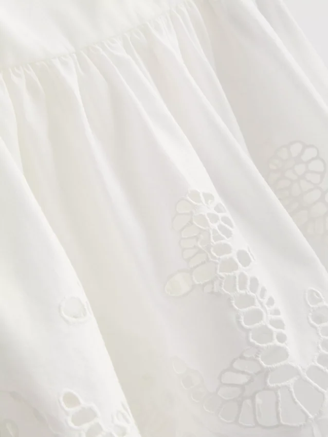 Top tipo camisola de algodón con bordado y dobladillo con volantes